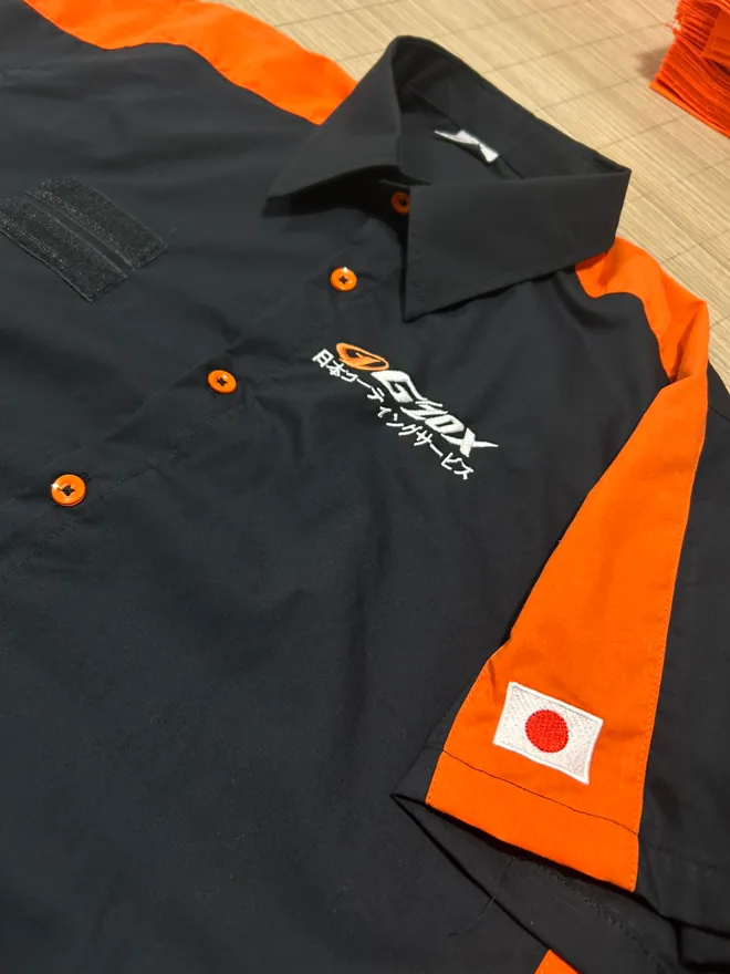 Camisa preta e laranja com bordado no peito