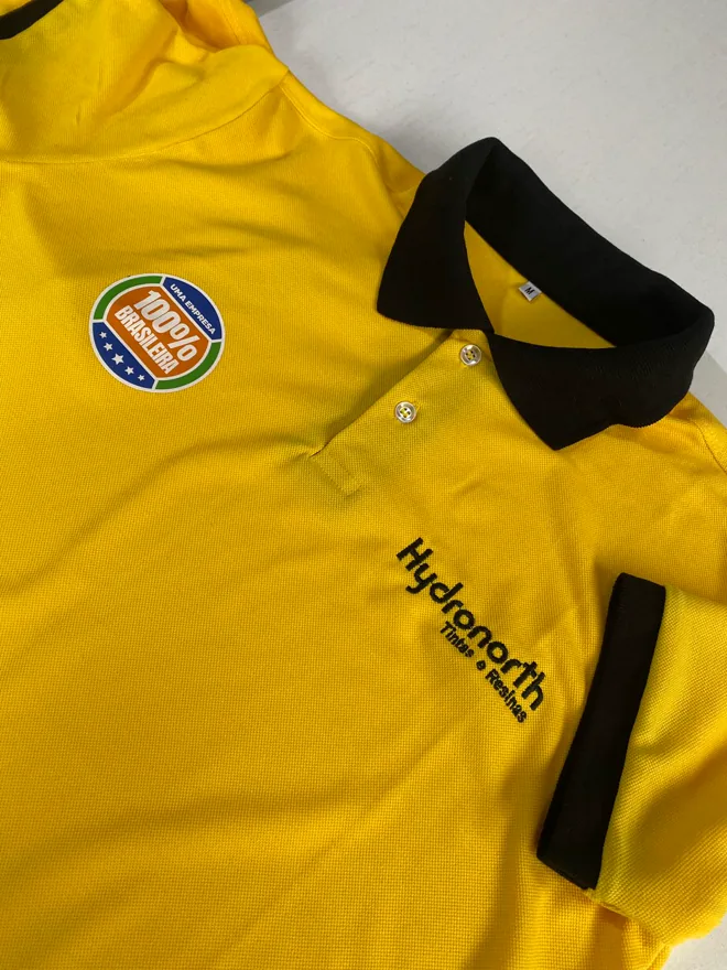 Polo amarela com gola preta e bordado no peito