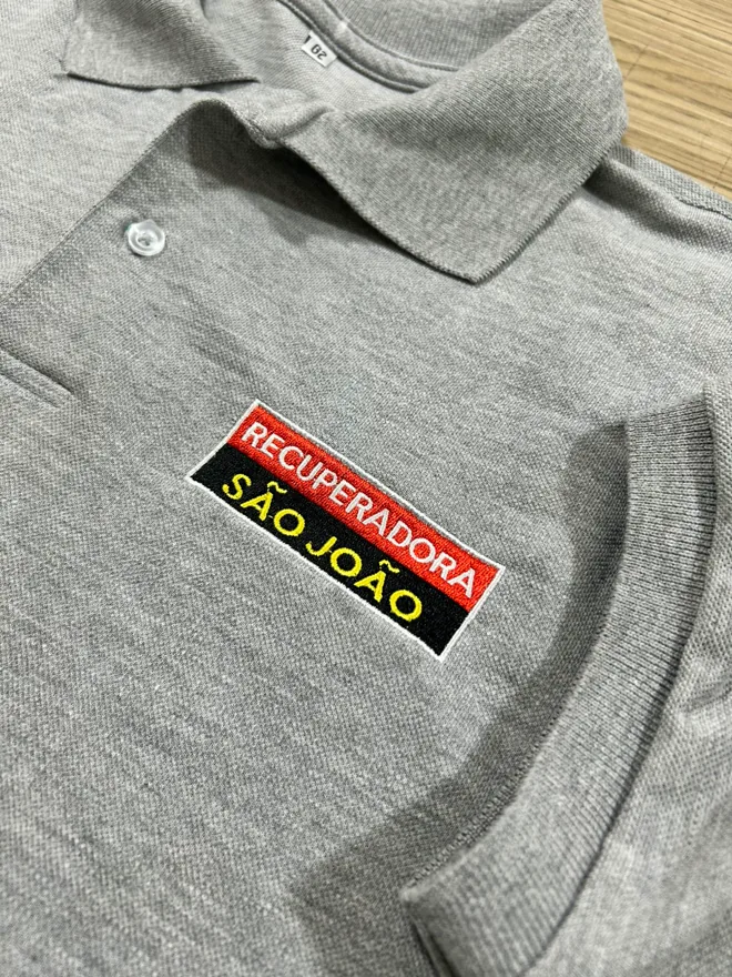 Polo cinza com etiqueta bordada no peito