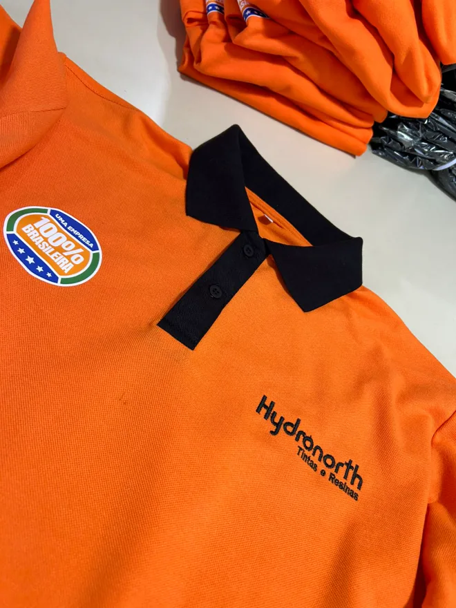 Polo laranja com gola preta e bordado no peito