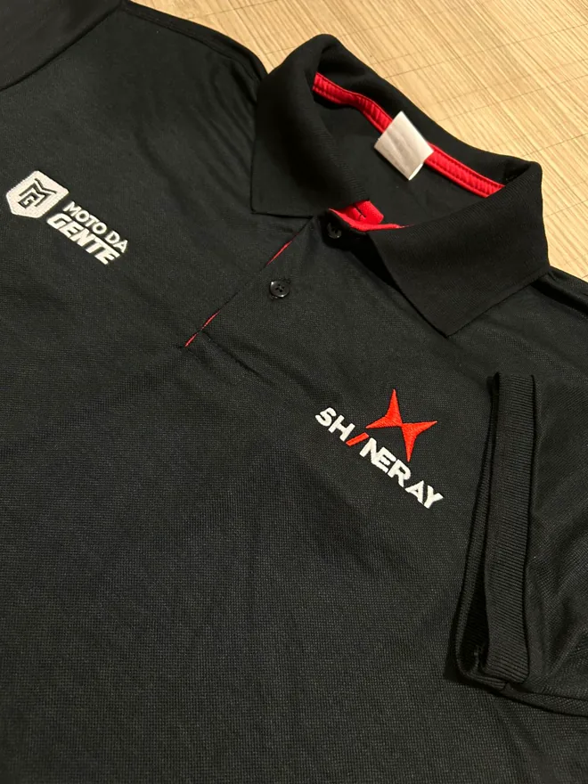 Polo preta com detalhe vermelho e bordado no peito